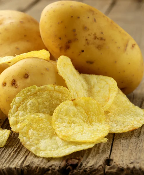 doğal patates cipsi ve ahşap zemin üzerine taze patates