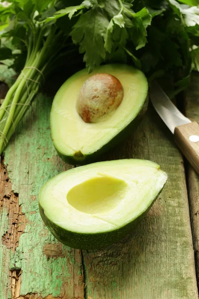 Rijpe avocado gesneden in de helft op een houten tafel — Stockfoto