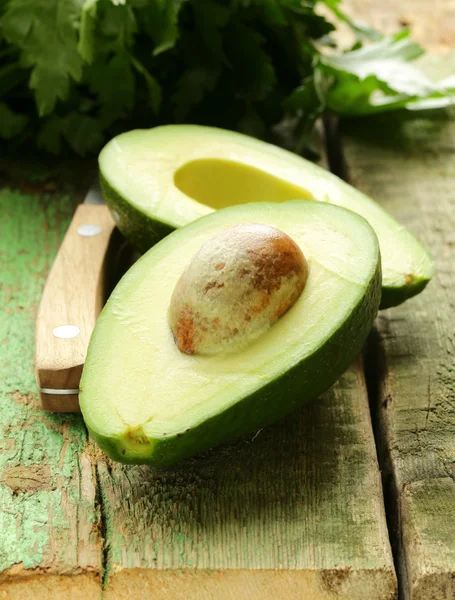 Avocado maturo tagliato a metà su un tavolo di legno — Foto Stock