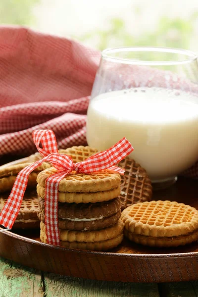 Homemade cookies (sandwich) with milk on a wooden table — Stock Photo, Image