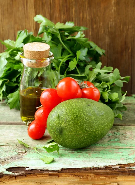 Натюрморт зі свіжих овочів (авокадо, помідор) оливкова олія та трави — стокове фото