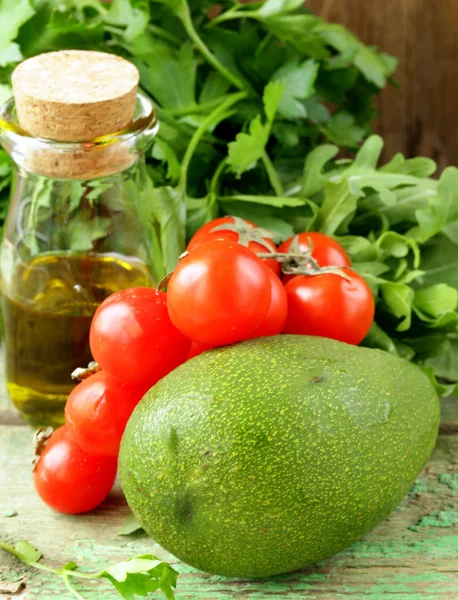 Still life of fresh vegetables (avocado, tomato) olive oil and herbs — Stock Photo, Image