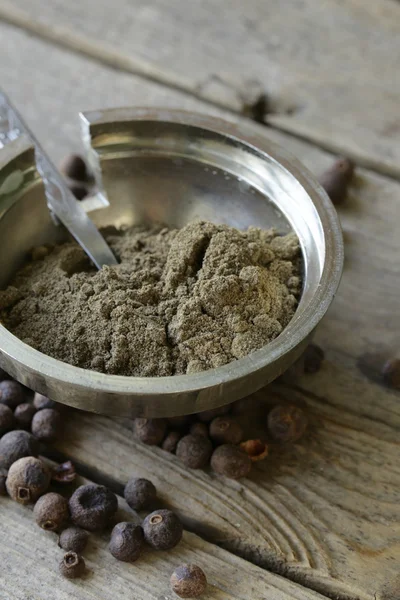 Gemalen zwarte peper op een houten tafel — Stockfoto