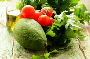 Natürmort otlar ve taze sebzeler (avokado, domates) zeytinyağı