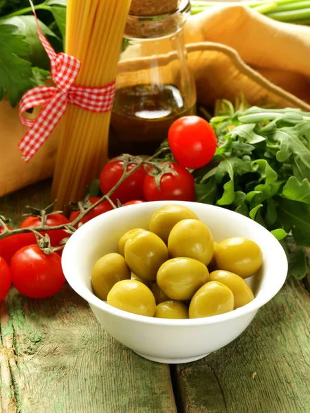 Натюрморт из оливок, трав, помидоров черри и итальянской пасты — стоковое фото