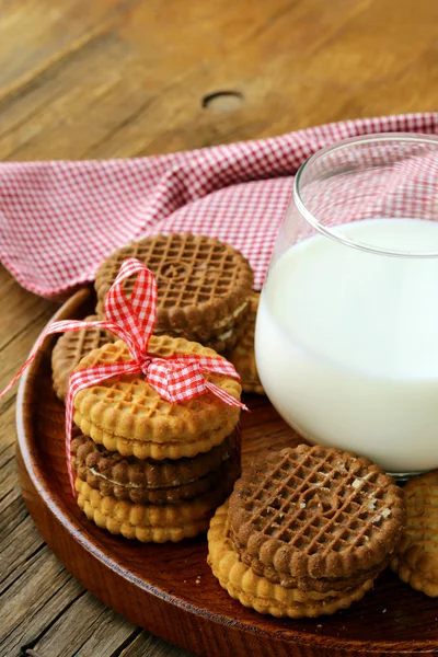Homemade cookies (sandwich) with milk on a wooden table — Stock Photo, Image