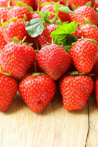 Viele frische reife Erdbeeren auf einem Holzbrett — Stockfoto