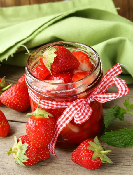 Marmellata di fragole in un barattolo e bacche fresche sul tavolo — Foto Stock