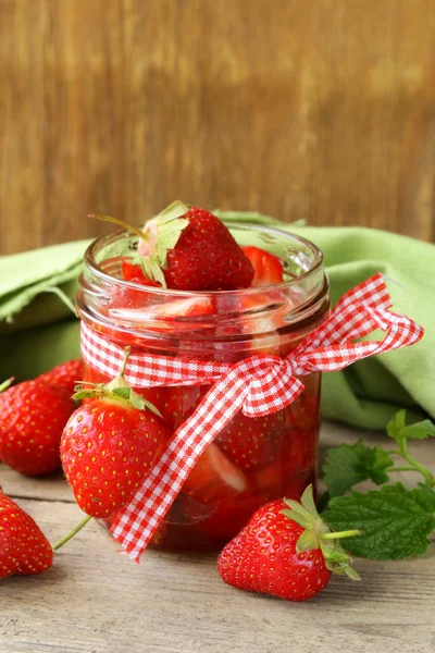 Erdbeermarmelade im Glas und frische Beeren auf dem Tisch — Stockfoto
