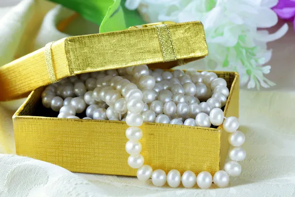 Collar de perlas en una caja de regalo de oro —  Fotos de Stock