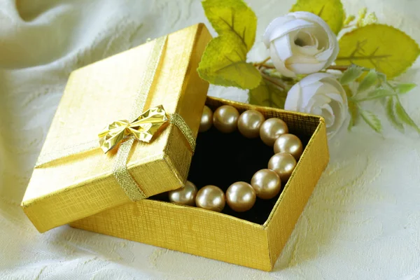 Collar de perlas en una caja de regalo de oro —  Fotos de Stock