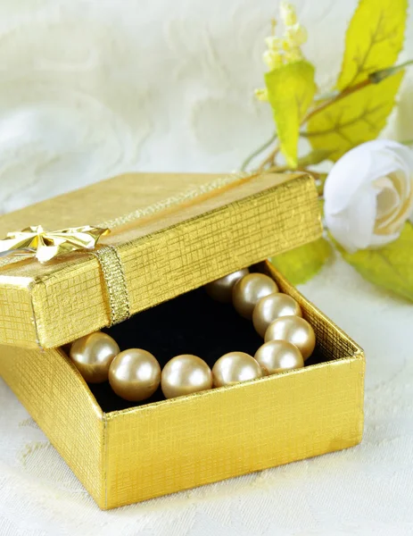 Pearl necklace in a gold gift box — Stock Photo, Image