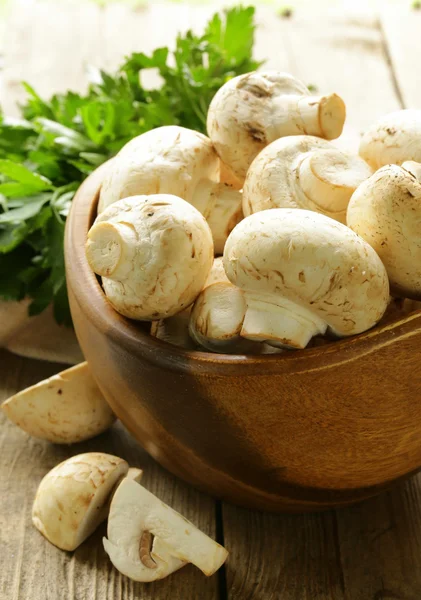 Fresh mushrooms (champignons) on a wooden table — Stock Photo, Image