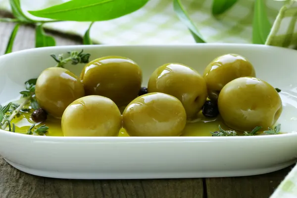 Groene olijven met geurende olie en specerijen — Stockfoto