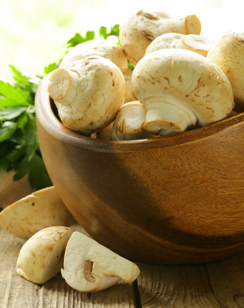 Färska champinjoner (champignons) på ett träbord — Stockfoto