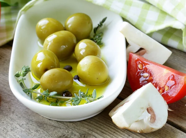 Green olives with fragrant oil and spices — Stock Photo, Image