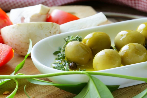 Green olives with fragrant oil and spices — Stock Photo, Image