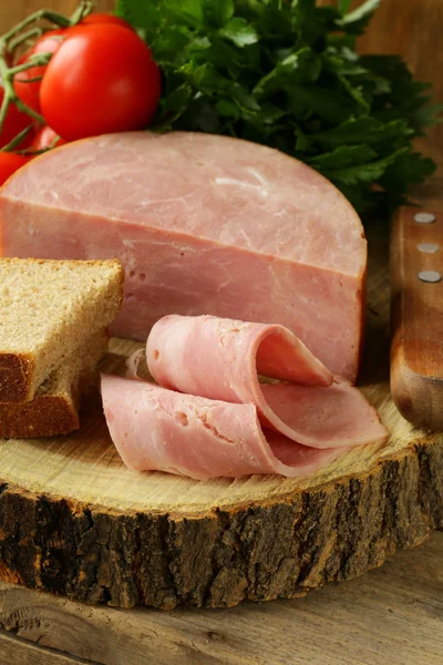Large piece of ham on a cutting board stump — Stock Photo, Image