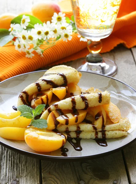 Tunna pannkakor (crepes) med persikor och chokladsås — Stockfoto