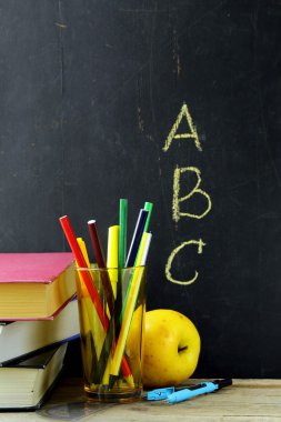 okul pano siyah arka plan üzerine bir kitap ve Kırtasiye (kalem, kurşun kalem, cetvel, pusula)