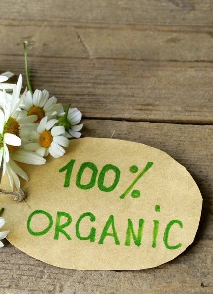 Organic label with daisies on natural background — Stock Photo, Image
