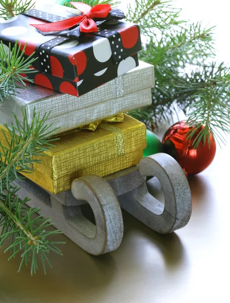 Composição de Natal - um trenó de madeira com presentes e ramos de abeto — Fotografia de Stock