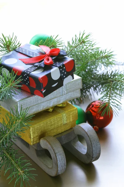 La composición de Navidad - el trineo de madera con los regalos y las ramas del abeto — Foto de Stock