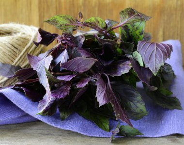 Ahşap bir masada bir demet mor fesleğen