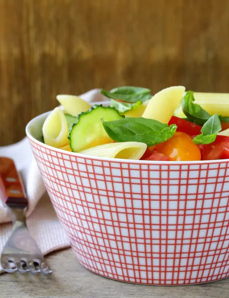 Pastasalade met komkommers, tomaten en basilicum — Stockfoto