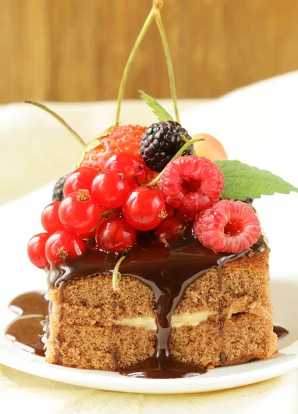 Schokoladenkuchen mit Beeren (Himbeere, Johannisbeere, Kirsche) und Schokoladensauce — Stockfoto