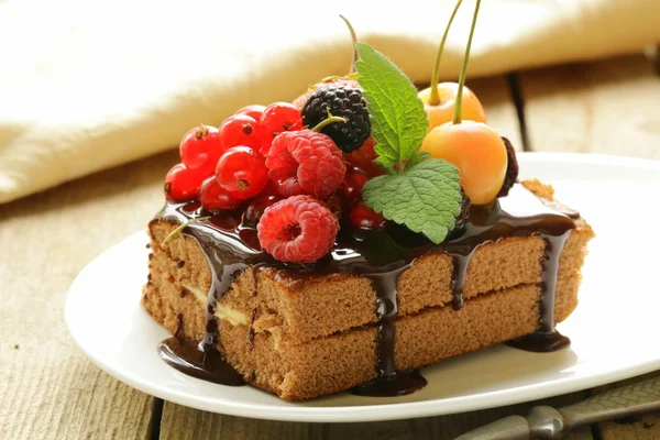 Chocolate cake with berries (raspberry, currant, cherry) and chocolate sauce — Stock Photo, Image