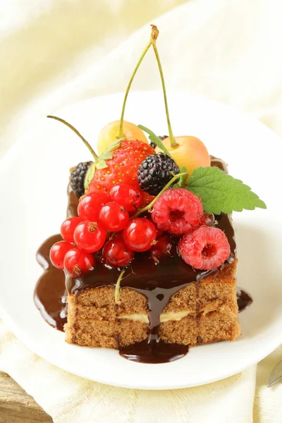 Schokoladenkuchen mit Beeren (Himbeere, Johannisbeere, Kirsche) und Schokoladensauce — Stockfoto