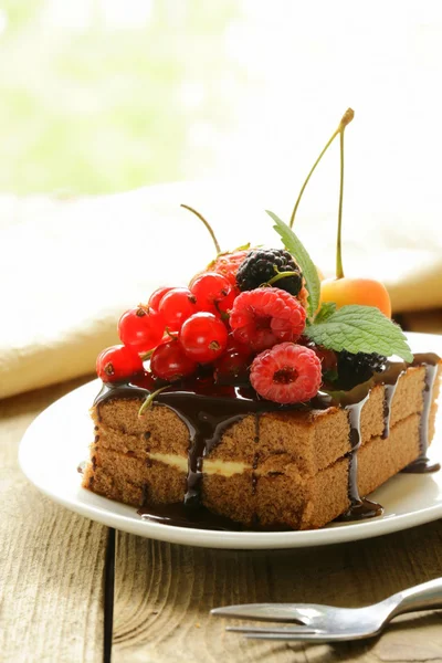 Schokoladenkuchen mit Beeren (Himbeere, Johannisbeere, Kirsche) und Schokoladensauce — Stockfoto