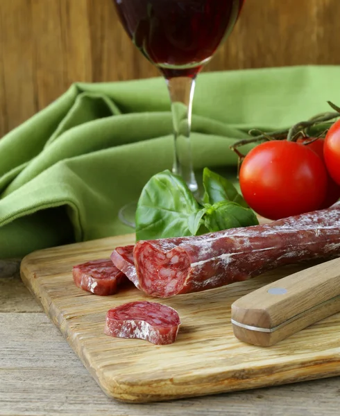 Bodegón de delicadeza salami, tomates y albahaca - estilo rústico — Foto de Stock