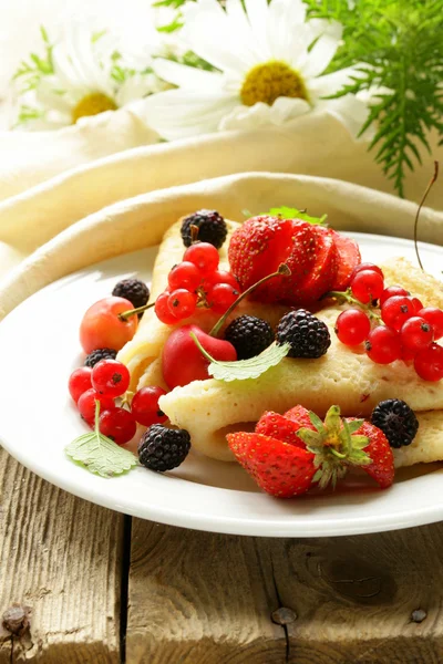 Thin dessert pancakes (crepes) with various berries — Stock Photo, Image