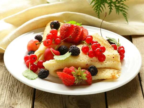 Thin dessert pancakes (crepes) with various berries — Stock Photo, Image