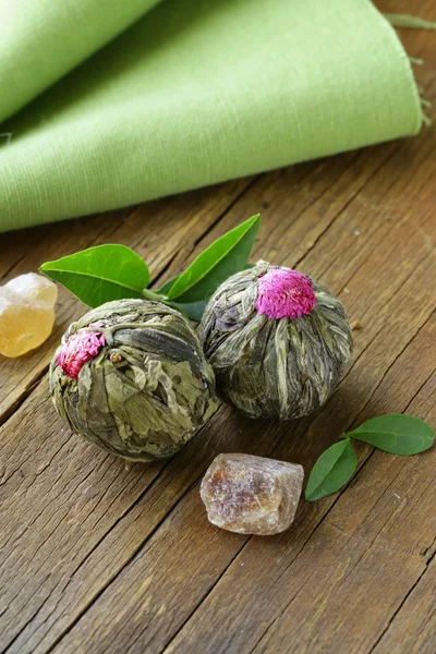 Exotische groene thee in de vorm van een bloem op een houten tafel — Stockfoto