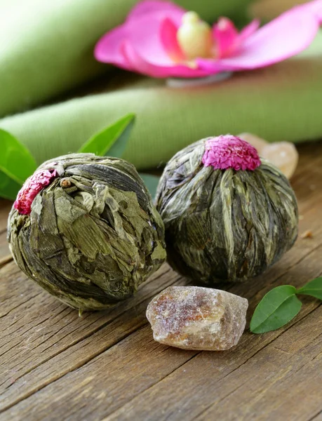 Exotischer grüner Tee in Form einer Blume auf einem Holztisch — Stockfoto