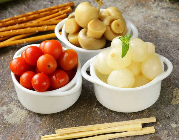 Aperitivos en escabeche (tapas): champiñones, tomates, pepinos y cebollas perlas —  Fotos de Stock