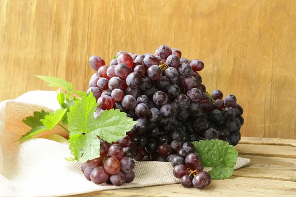 Uvas pretas maduras orgânicas em uma mesa de madeira — Fotografia de Stock