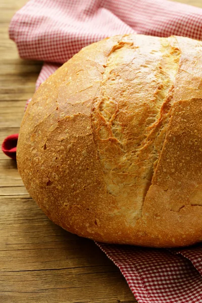 Large loaf of homemade bread with a kitchen towel — Stock Photo, Image