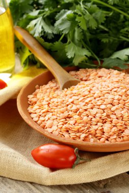 ahşap bir masa üzerinde bir kil kase kırmızı mercimek