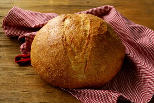 Großer Laib selbstgebackenes Brot mit einem Küchentuch — Stockfoto