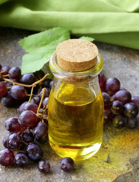 Бутылка с виноградным маслом на деревянном столе — стоковое фото