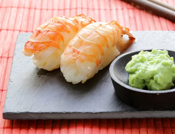 Gedeelte van sushi met garnalen op een stenen plaat — Stockfoto