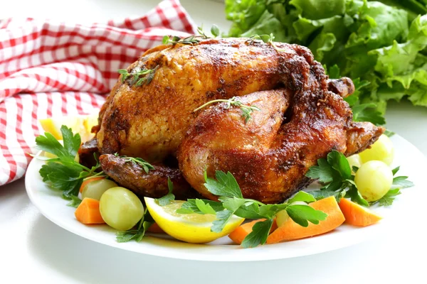 Roasted chicken with herbs served on a plate with lemon — Stock Photo, Image