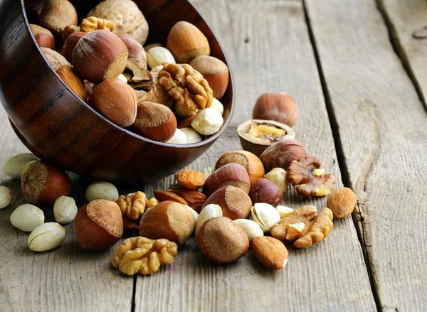 Nüsse (Mandeln, Haselnüsse, Walnüsse) auf einem Holztisch mischen — Stockfoto