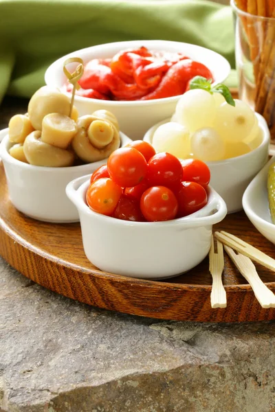 Pickled snacks (tapas) - mushrooms, tomatoes, cucumbers and pearl onions — Stock Photo, Image