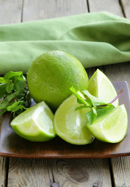 Fresh limes with green mint - chopped and whole — Stock Photo, Image