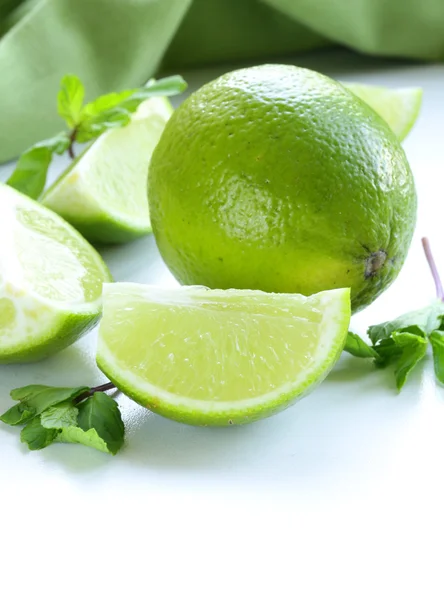 Fresh limes with green mint - chopped and whole — Stock Photo, Image